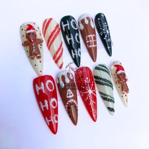 May include: Set of ten Christmas-themed nail art designs. The designs include gingerbread men, candy canes, snowflakes, and the words "Ho Ho Ho".