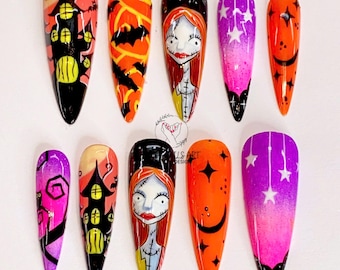 Puede incluir: Diez uñas postizas largas y puntiagudas con diseños de temática de Halloween. Los diseños incluyen una casa negra con ventanas amarillas, una calabaza de Halloween, una luna creciente, estrellas y un personaje de la película Pesadilla antes de Navidad.