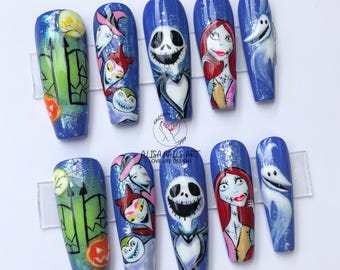 Puede incluir: Conjunto de diez puntas de uñas azules, blancas y verdes con un tema de Pesadilla antes de Navidad. Las puntas presentan a Jack Skellington, Sally y Zero.