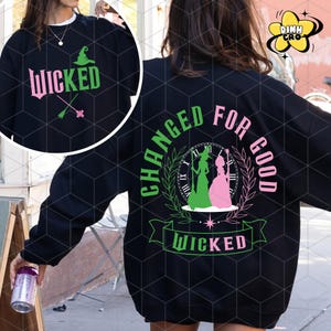 May include: Black sweatshirt with a green and pink graphic design featuring the text "Changed for Good" and "Wicked". The graphic includes a clock, two witches, and a star.