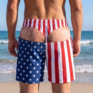 May include: Swim shorts featuring a split design with a blue field of white stars on the left and red and white vertical stripes on the right. The garment includes an integrated thong-style waistband section with matching red and white stripes.