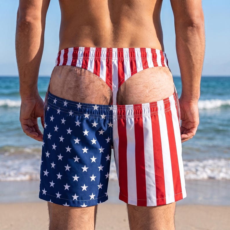 May include: Swim shorts featuring a split design with a blue field of white stars on the left and red and white vertical stripes on the right. The garment includes an integrated thong-style waistband section with matching red and white stripes.