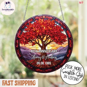 May include: A circular stained glass suncatcher featuring a tree with red leaves and a brown trunk, set against a sunset. The text reads "40th Anniversary Henry & Audrey 09.08.1985". Includes a chain for hanging, perfect for a window.