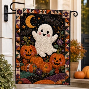 Puede incluir: Una bandera de jardín acolchada rectangular que presenta un fantasma blanco central con cara sonriente, rodeado de calabazas naranjas, una luna creciente amarilla y dos murciélagos negros sobre un fondo negro, enmarcado por un borde geométrico.