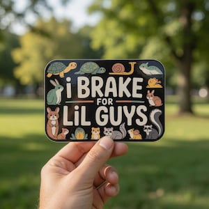 May include: A rectangular sticker with the text "i BRAKE FOR Lil GUYS" in white and green. The sticker features illustrations of various animals, including turtles, rabbits, and raccoons, against a black background.