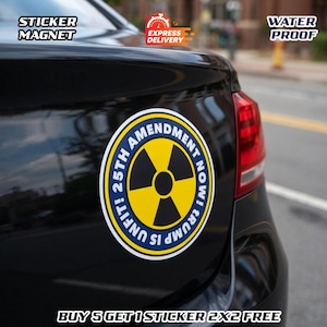 May include: A round sticker magnet on a black car. The sticker has a yellow and black radiation symbol in the center, surrounded by a blue ring with the text "UNFIT! 25TH AMENDMENT NOW! TRUMP IS". The sticker is labeled "STICKER MAGNET" and "WATER PROOF".