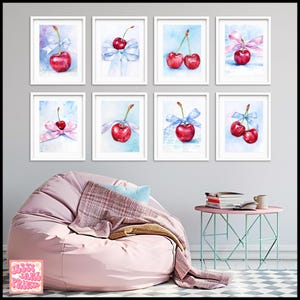 May include: Eight framed watercolor paintings of cherries with blue and pink ribbons on a light blue background. The paintings are arranged in a grid of two rows and four columns. The paintings are hanging on a gray wall.