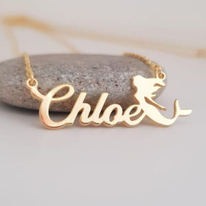 May include: Gold necklace with the name "Chloe" in cursive script and a mermaid silhouette charm.
