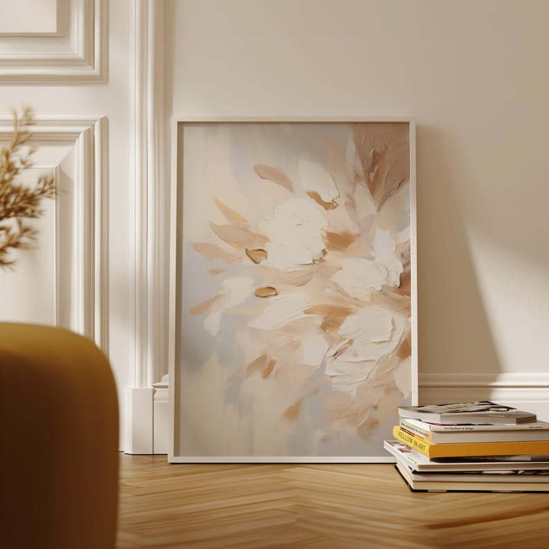 May include: A framed abstract painting with a white background and soft brown and beige brushstrokes. The painting is in a white frame and is hanging on a white wall.