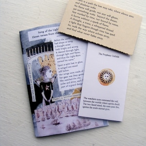 May include: A collection of printed cards and a booklet with text and illustrations. The booklet is titled "Song of the Light" and features a drawing of a winged figure. The cards have quotes and the title "The Prophesy Unfolds".