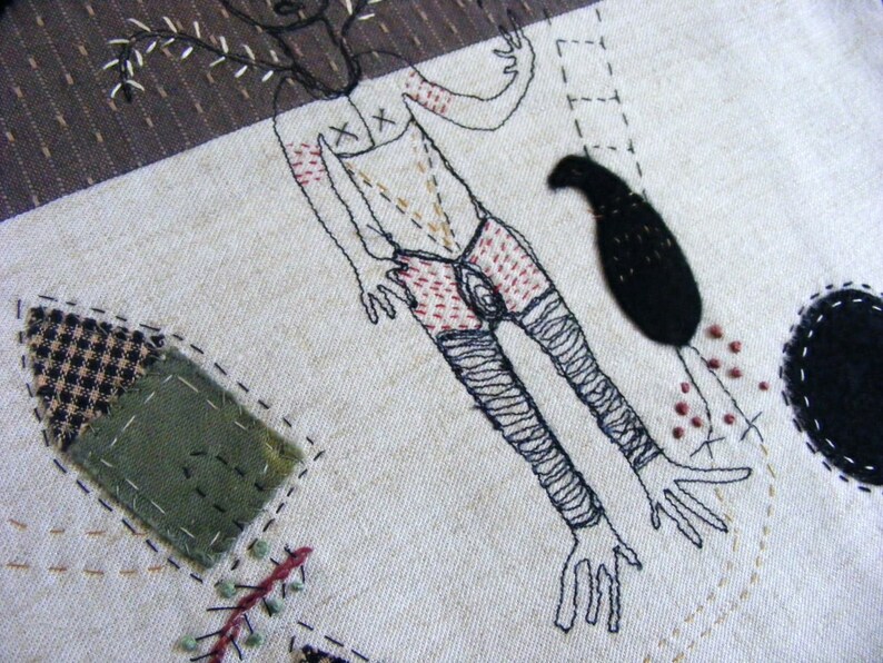 May include: Embroidered artwork featuring a stylized human figure with a tree growing from its head, a black bird, and a black circle. The artwork is stitched on a beige fabric background.