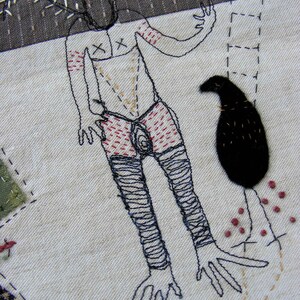 May include: Embroidered artwork depicting a stylized human figure with a bird and a floral design. The figure is outlined in black thread and has red and brown details. The bird is black and the floral design is in shades of brown.