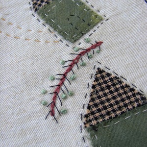 May include: A close-up of a fabric patchwork design with a green, black and white checkered pattern, a green fabric, and a red and green stitched design.