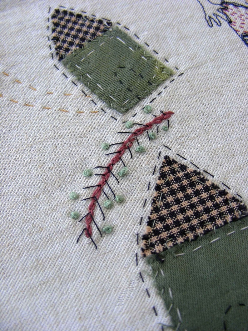 May include: A close-up of a fabric patchwork design with a green, black and white checkered pattern, a green fabric, and a red and green stitched design.