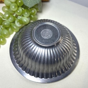 Op de afbeelding: Een set van drie keramische mokken met een gespikkelde, matte afwerking. De mokken zijn in cr&egrave;me, lichtgrijs en donkergrijs. Elke mok heeft een eenvoudig, minimalistisch ontwerp.