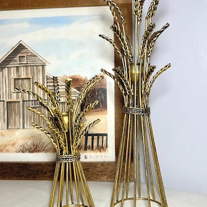 May include: A white ceramic mug with a black handle and the text "But First, Coffee" in a bold, black font. The mug is set against a blurred background, highlighting its simple design.