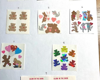 May include: Nine sheets of stickers featuring various designs of bears, bunnies, mice, and hearts. The stickers are on a white background and have a glossy finish. Some of the stickers are glow-in-the-dark.