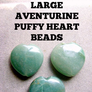 以下が含まれることがあります： 緑色のアベンチュリン製のハート型のビーズが3つ。ビーズは滑らかで磨かれており、わずかに光沢があります。