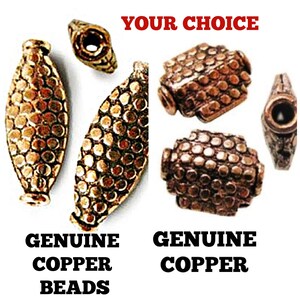 Puede incluir: Un surtido de cuentas de cobre genuinas en varias formas. La imagen muestra cuentas alargadas, ovaladas y cuentas redondeadas, en forma de cubo. El texto "YOUR CHOICE" está en la parte superior, con "GENUINE COPPER BEADS" debajo de las cuentas ovaladas y "GENUINE COPPER" debajo de las cuentas cúbicas.
