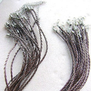 Peut inclure: Un lot de colliers en cordon de cuir marron avec des fermoirs argentés. Les cordons sont tressés et ont un aspect rustique.