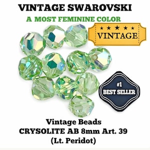 May include: A collection of light green Swarovski crystal beads, labeled as "Vintage" and "Best Seller." The beads are faceted and have an iridescent quality. Text on the image reads "CRYSOLITE AB 8mm Art. 39 (Lt. Peridot)."