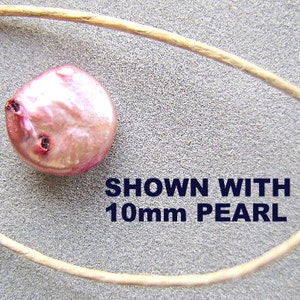 Puede incluir: Una perla redonda de color rosa iridiscente con hendiduras oscuras visibles en la superficie, colocada junto a un cord&oacute;n fino de color marr&oacute;n claro. El texto SHOWN WITH 10mm PEARL est&aacute; impreso en letras azul oscuro cerca de la perla.