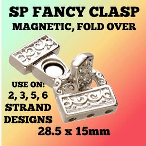May include: A silver-colored magnetic clasp with an ornate design. The text on the image reads "SP FANCY CLASP MAGNETIC, FOLD OVER" and "USE ON: 2, 3, 5, 6 STRAND DESIGNS". The clasp measures 1.12 x 0.59 inches.