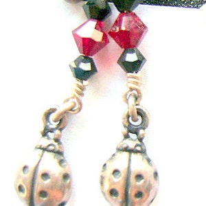 May include: A pair of silver ladybug earrings with black and red crystal beads.