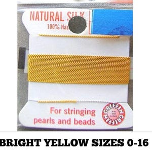 May include: A spool of bright yellow natural silk thread for stringing pearls and beads. The white cardboard packaging features the text Natural Silk 100% Natural and Griffin For stringing pearls and beads with a circular logo in the corner.