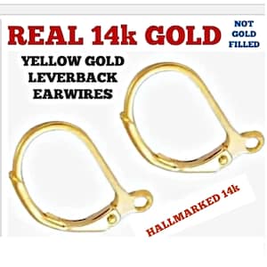 May include: Two yellow gold leverback earwires. The image includes the text "REAL 14k GOLD" and "HALLMARKED 14k". The earwires are not gold filled.