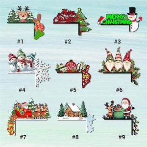 May include: A collection of nine Christmas-themed corner decorations. Designs include a reindeer, Christmas tree, snowman, snowmen, ornaments, gnomes, Santa Claus with a sleigh, a cabin, and Santa with a bag of gifts. Each piece has a black corner.