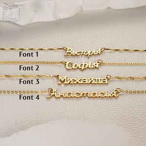 May include: Four gold-toned name necklaces displayed horizontally, each featuring a different chain style and Cyrillic script name. The labels Font 1, Font 2, Font 3, and Font 4 are positioned to the left of each respective necklace, showing name variations.