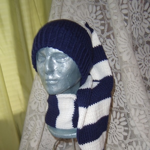 May include: A blue and white striped knit hat with a long tail. The hat is made of soft yarn and has a pom-pom on the end of the tail.