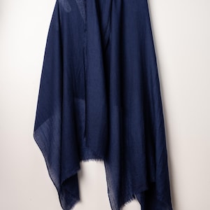 May include: A navy blue scarf with a fringed edge.