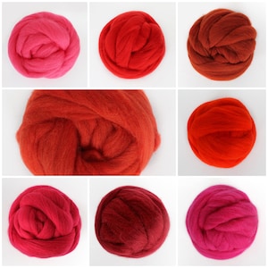May include: Assortment of red, orange, and pink wool roving in various shades. The wool is arranged in balls and is ready for felting or spinning.