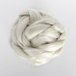 May include: A close-up of a clump of white, fluffy fiber. The fiber is soft and appears to be natural.