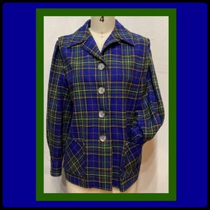 May include: A blue, green, and yellow plaid jacket with a collared neckline and three large buttons. The jacket has two front pockets and is displayed on a mannequin. The plaid pattern is a classic design.