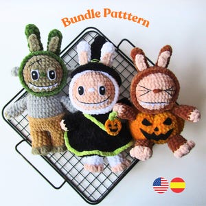 Puede incluir: Tres muñecos de conejito de ganchillo hechos a mano con disfraces de Halloween. Uno es verde, gris y beige, otro es negro y blanco, y el tercero es naranja y marrón. Los muñecos se exhiben en una rejilla de alambre negra. El texto "Bundle Pattern" está en la parte superior.