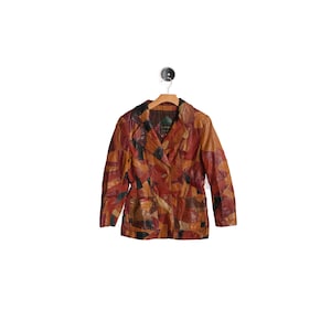 May include: A patchwork leather jacket featuring a multi-colored design with various shades of brown, red, orange, and black. The jacket includes a notched collar, long sleeves, a button-front closure, and two front pockets, all displayed on a hanger.