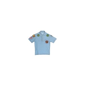 May include: A light blue short-sleeve polo shirt featuring a collar, a three-button placket, and multiple circular and rectangular embroidered patches attached to the chest, shoulders, and sleeves, including a patch on the left chest pocket.