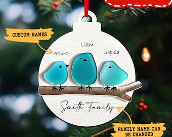 May include: A personalized Christmas ornament featuring three blue bird figures perched on a branch. The ornament is white with the family name "Smith Family" and the names "Liam", "Azura", and "Sophia". The text "CUSTOM NAMES" and "FAMILY NAME CAN BE CHANGED" are also visible.