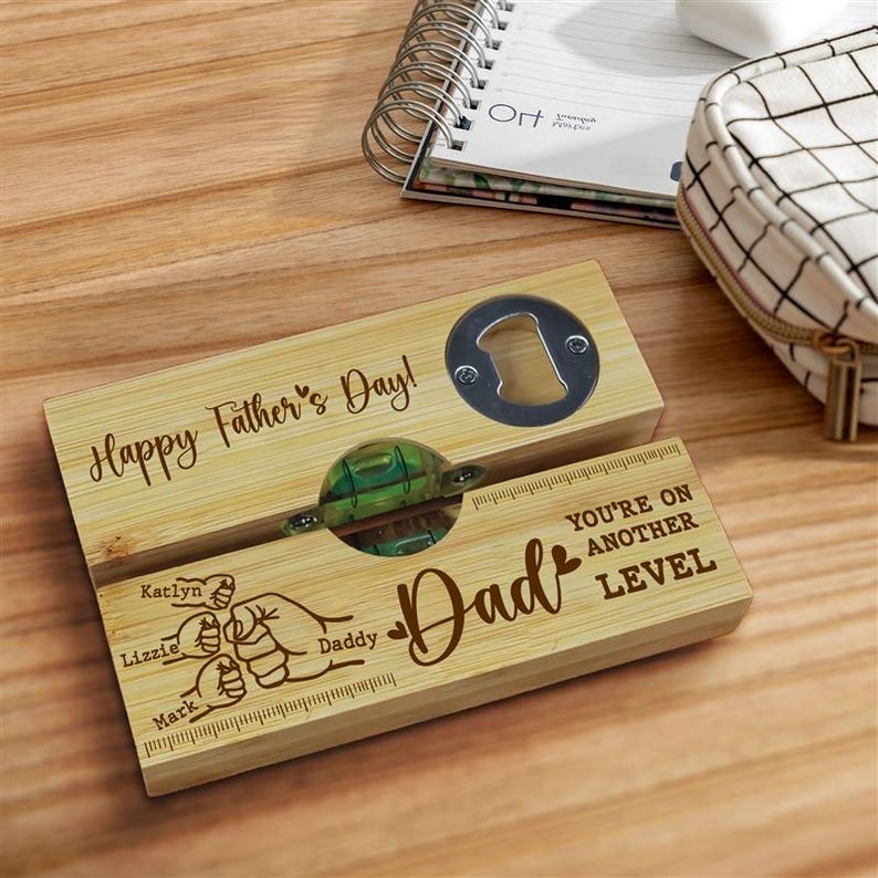 Pu&ograve; includere: Un apribottiglie in legno con la scritta "Happy Father's Day!" e "Dad" incisa. Include una livella e un apribottiglie. I nomi "Katlyn", "Lizzie" e "Mark" sono anch'essi incisi.