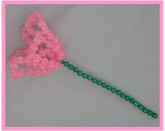 May include: A pink beaded flower with a green beaded stem.