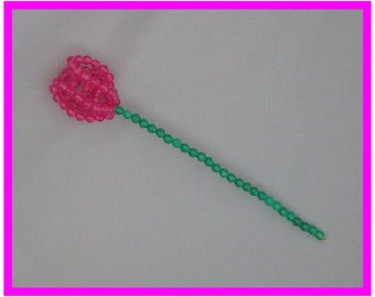 May include: A pink beaded flower with a green beaded stem.
