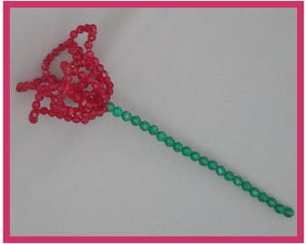 May include: A red beaded flower with a green beaded stem.