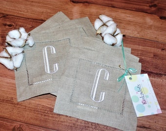 May include: Set of four linen napkins with a white embroidered letter C on each. The napkins are tied together with a green ribbon and a tag that says "Kokadots".