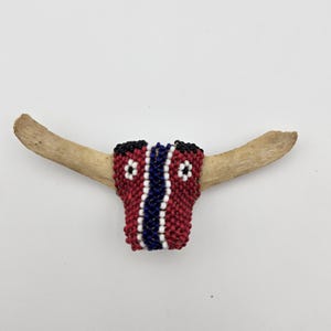 Vintage handmade Native American beaded bolo tie slide / pin of steer: dark red, white, navy blue, and black beads on cow tail bone