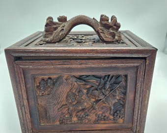 Raro juego de Mah Jong de la década de 1920, exquisitamente tallado a mano, en forma de caja de madera, con escenas de guerreros y pueblos, y fichas de hueso y bambú.