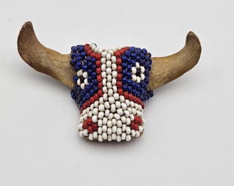 Vintage handgemachte indianische Glasperlenschleife eines Stiers: weiße, rote, blaue Perlen auf Kuhschwanzknochen