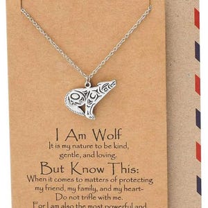 Puede incluir: Un collar de plata con un colgante de lobo y una tarjeta que dice "Soy un lobo. Es mi naturaleza ser amable, gentil y cariñoso. Pero ten en cuenta esto: Cuando se trata de proteger a mi amigo, mi familia y mi corazón, no te burles de mí. Porque también soy la criatura más poderosa e implacable que jamás conocerás. HECHO A MANO"